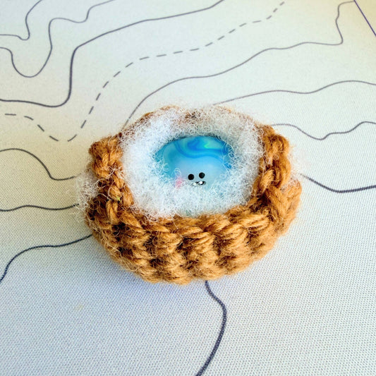 A handmade special edition Bonino - 90s water elemental swirl design - sitting in handmade crochet basket.